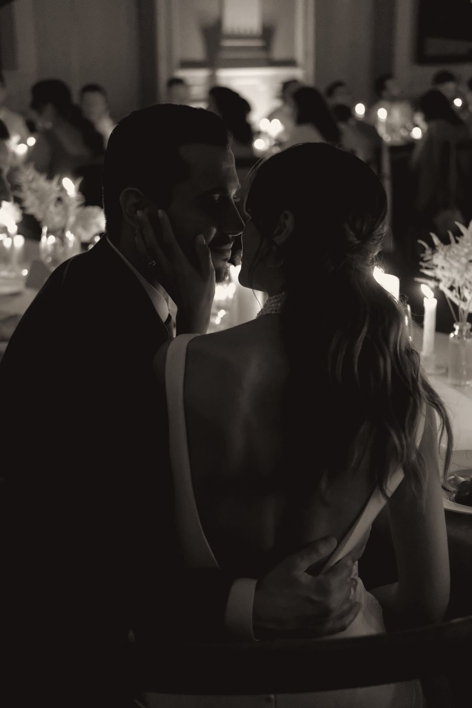 Couple kissing at a candlelit dinner